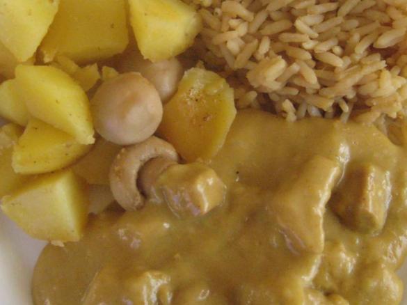 Putengeschnetzeltes in Currysoße mit Reis und Kartoffelwürfel