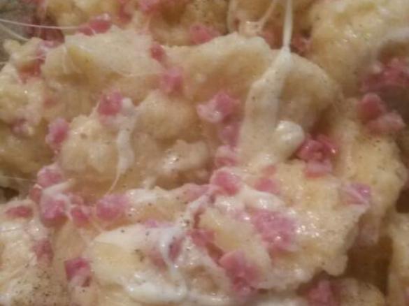 Mehlklöße in Käse und Speck gewendet