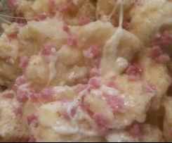 Mehlklöße in Käse und Speck gewendet