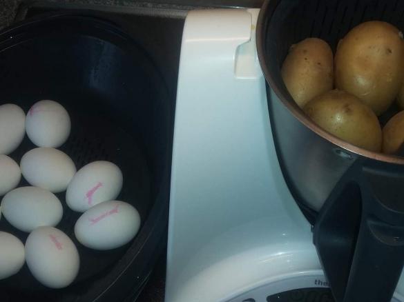 Gleichzeitig kochen Eier und Kartoffeln