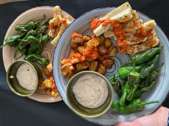 Tapas-Platte mit selbst gemachter Mojo Rojo, Joghurt Aioli, Halloumi, Pimientos de Padrón und Patatas Bravas